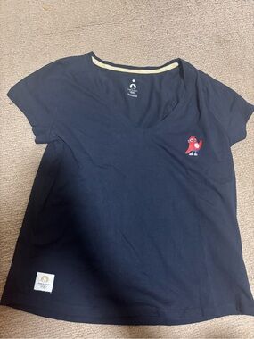 Women shirt - Paris Olympics 2024. Size M. Navy V‑Neck Tee with olympics logo.